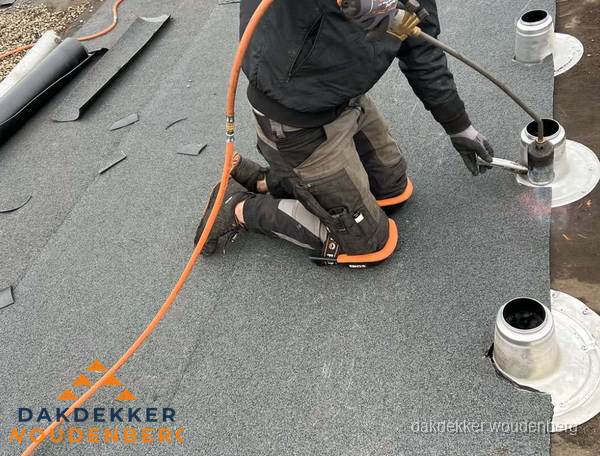 Dakdekker repareert bitumen dakleer bij dakdoorvoer in Woudenberg