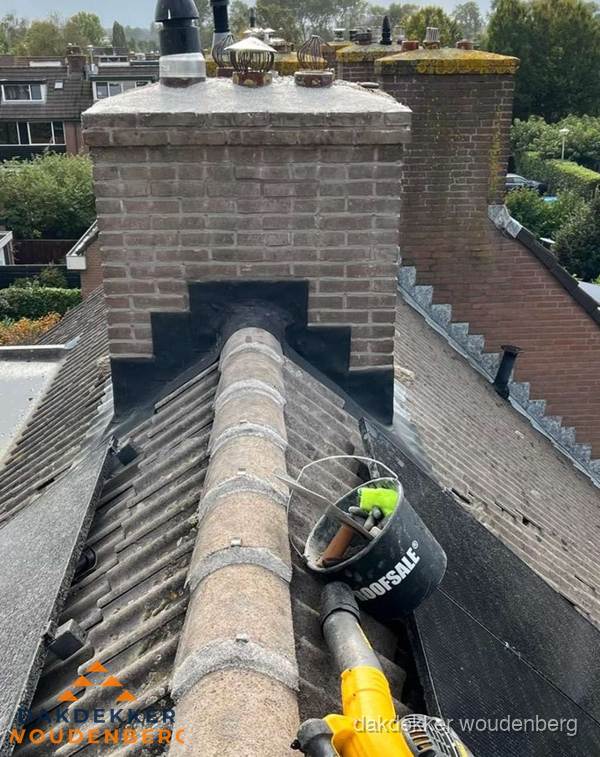 Schoorsteen met loodaansluiting en nokvorst op pannendak in Woudenberg