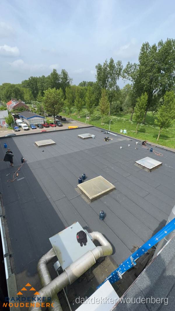 Dakdekker aan het werk op groot plat dak met bitumen in Woudenberg Dakdekker aan het werk op groot plat dak met bitumen in Woudenberg